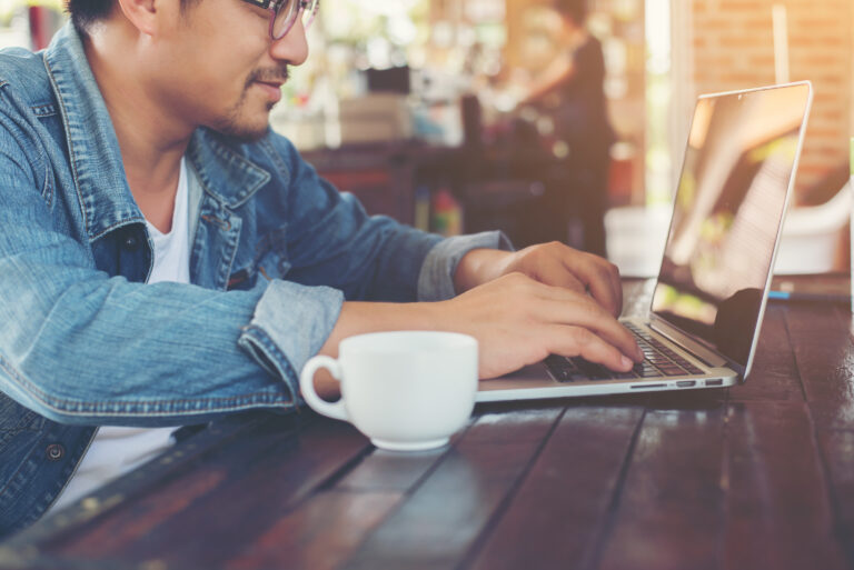 Hipster man in a cafe, using laptop to create a branding strategy
